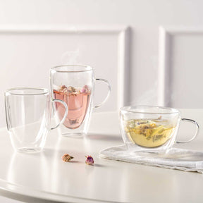Doppelwandtassen DUO mit Tee und Kräutertee auf weißem Tisch