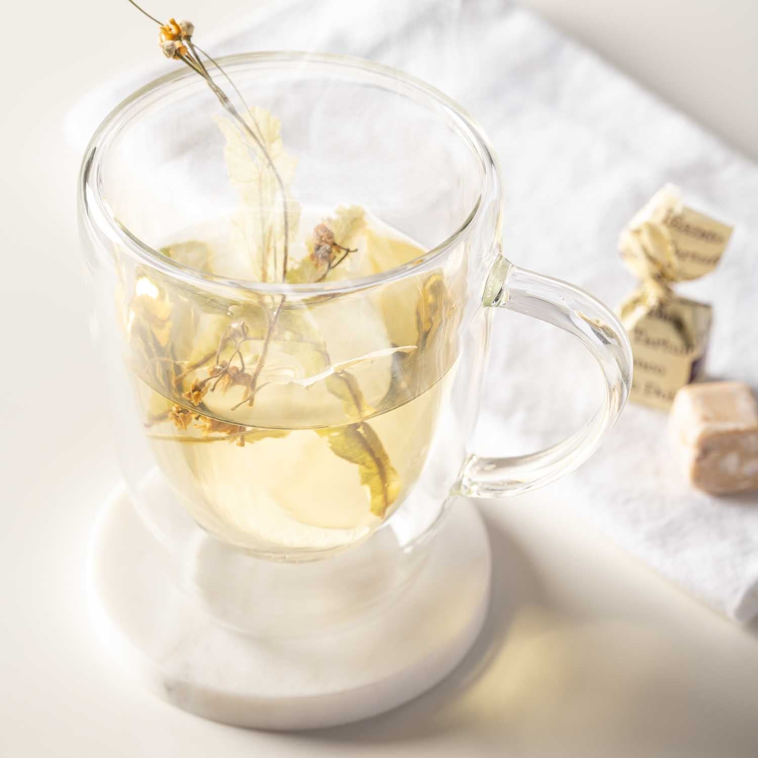 Doppelwandtasse DUO mit Tee, Teetasse wird befüllt, auf Untersetzer