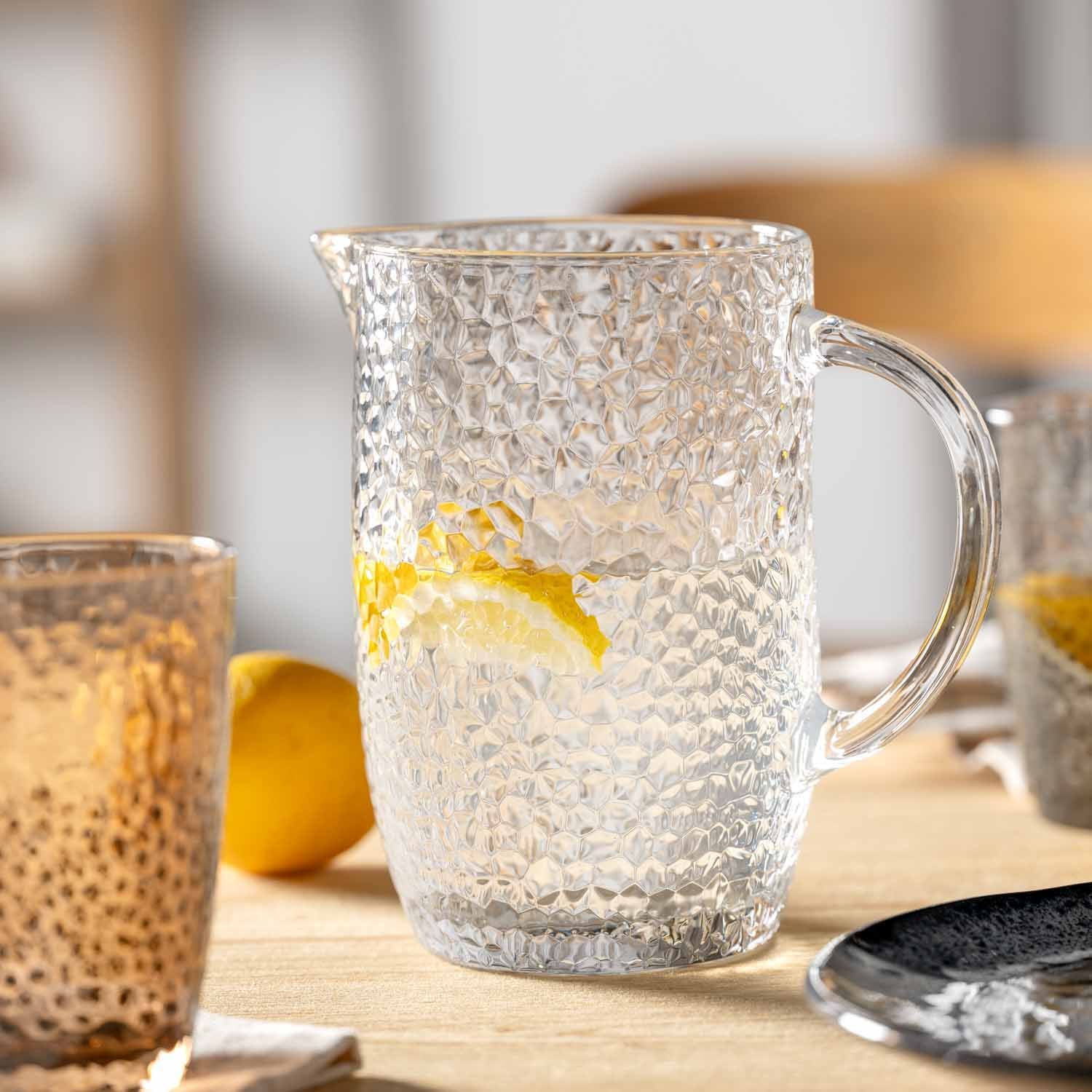 Krug MATERA mit Zitronenscheibe auf Holztisch, Glas daneben