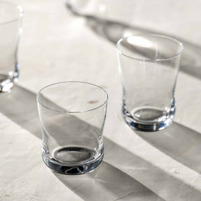 Trinkglas VITA auf Marmortisch mit Sonnenschatten, mehrere Gläser nebeneinander