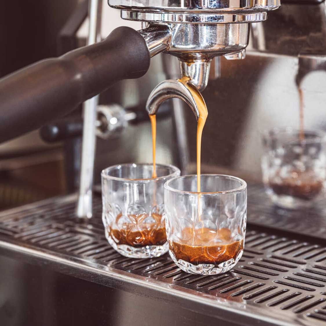 Espressoglas GOCCE wird an Espressomaschine gefüllt, zwei Gläser auf Maschine