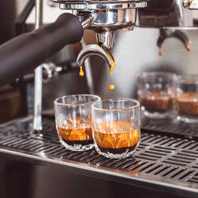 Espressoglas GOCCE 60ml wird an Espressomaschine gefüllt, zwei Gläser auf Maschine