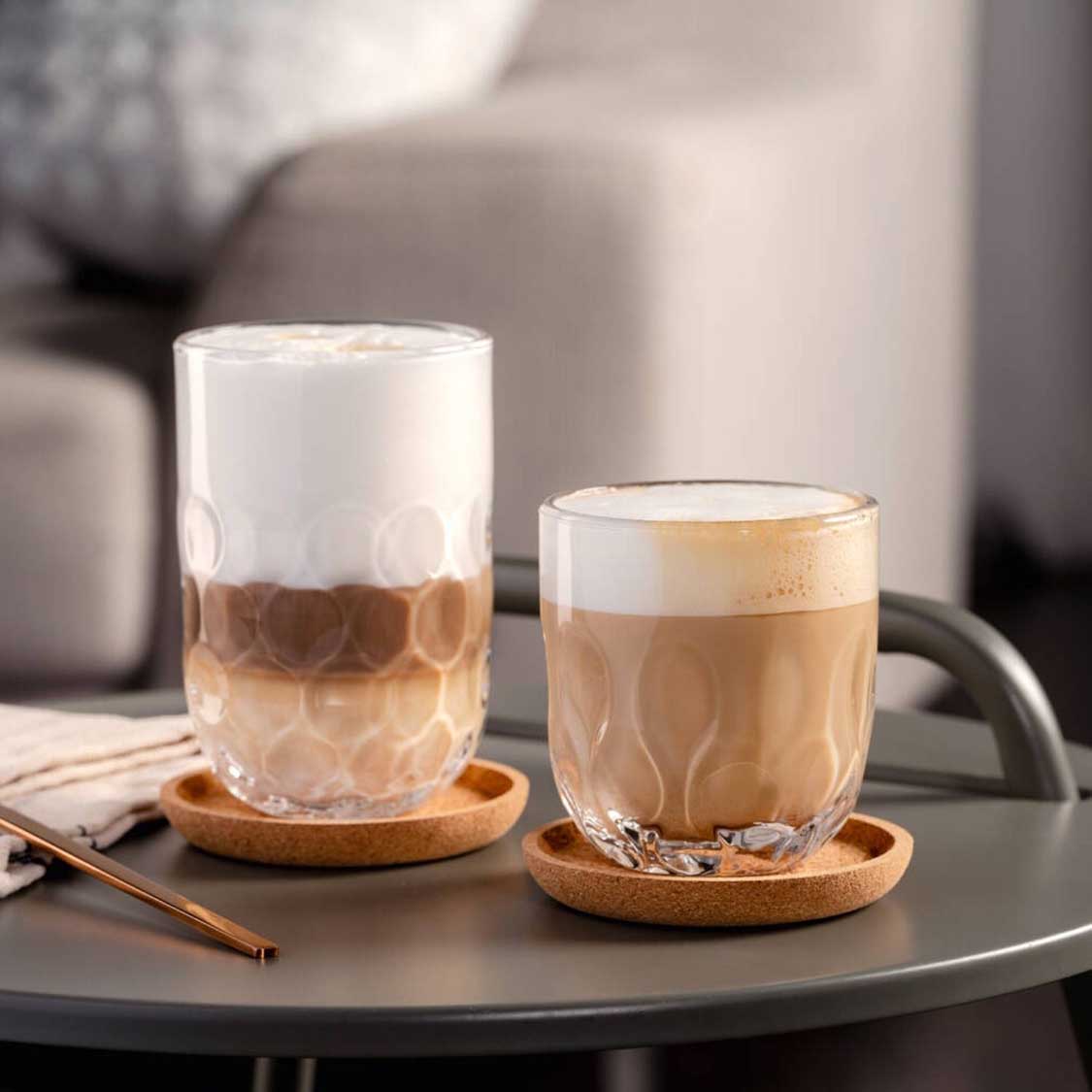 Zwei Kaffeegläser GOCCE mit Kaffee auf Korkuntersetzern auf grauem Tablett