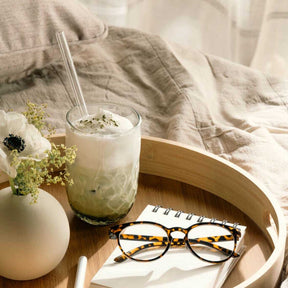 Latte Macchiato Glas GOCCE mit Getränk, Blume und Brille auf Holztablett