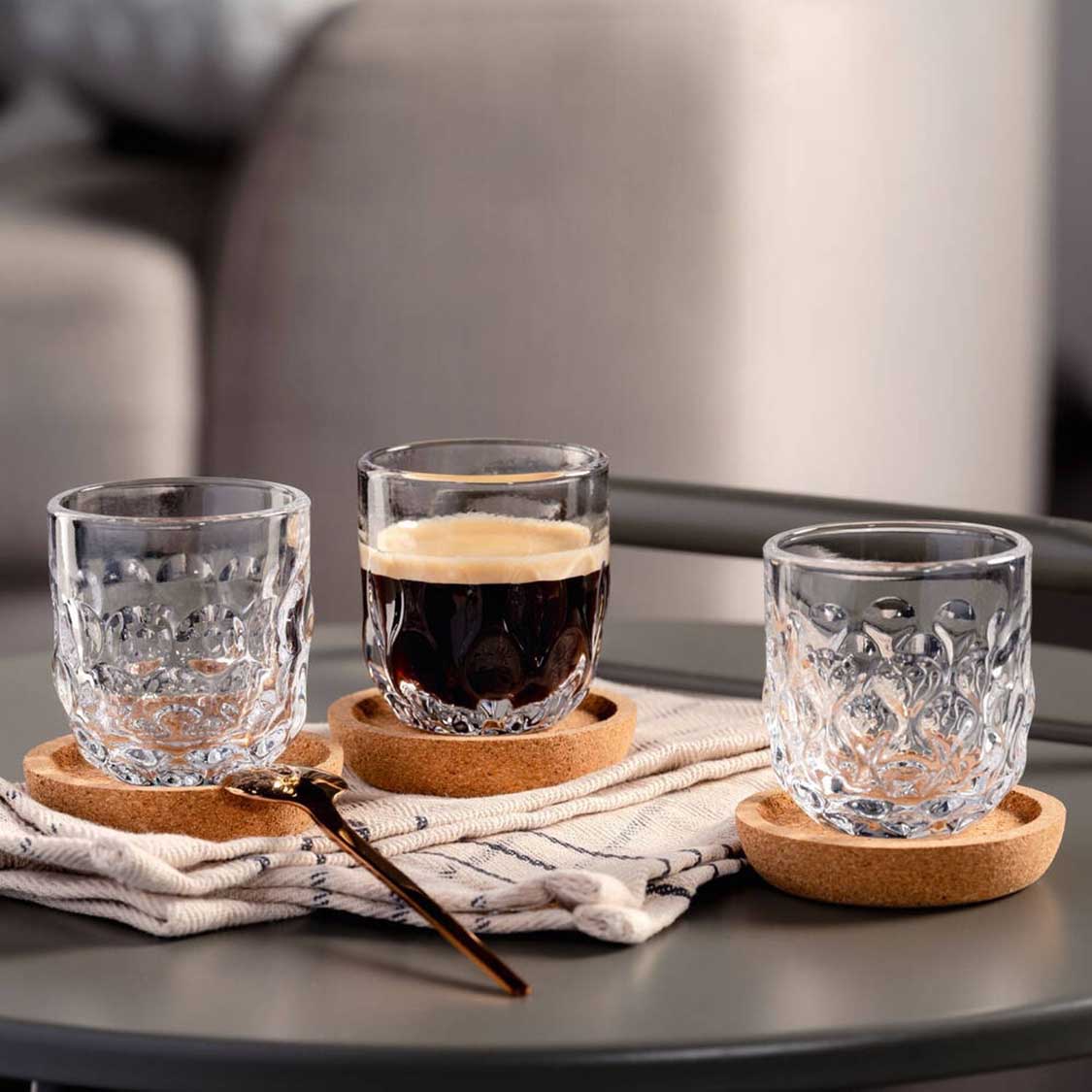Espressoset GOCCE 6-teilig auf Tisch mit Korkuntersetzern und Leinenserviette