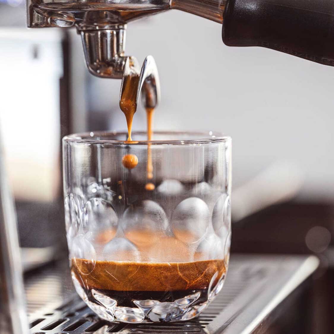 Espressomaschine gießt Kaffee in Kaffeeset GOCCE 6-teilig mit Eiswürfeln