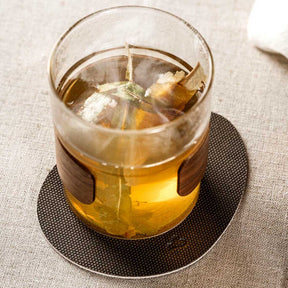 Untersetzer GOCCE grau unter Glas mit Whiskey und Eiswürfeln