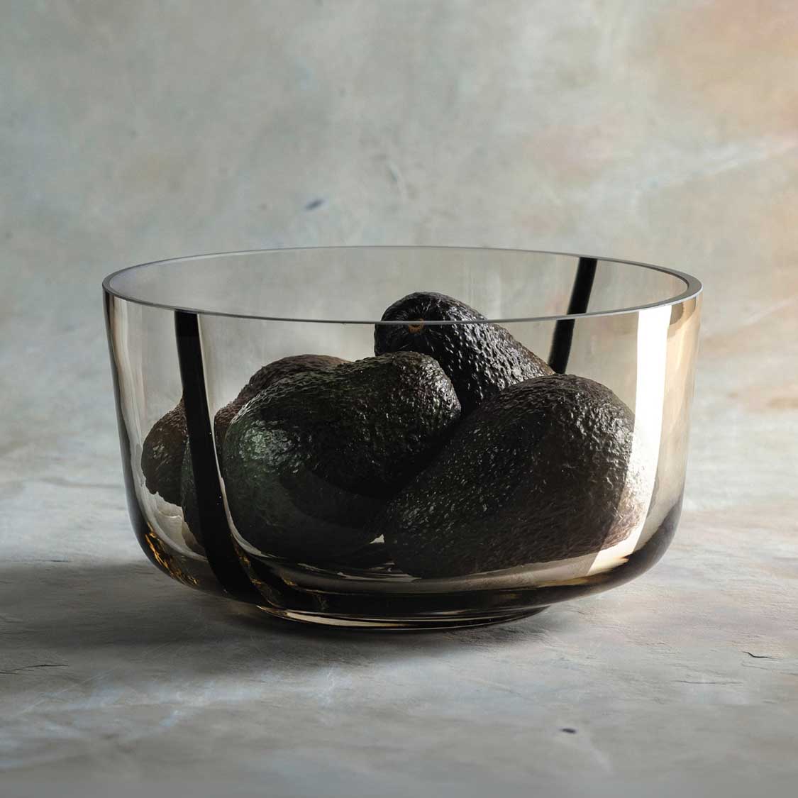 Schale ALVEO mit schwarzen Avocados gefüllt auf grauem Untergrund