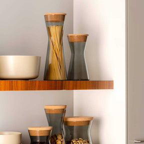 Dose FORMA X grau mit Holzdeckel auf Regal zwischen anderen Behältern und Schalen