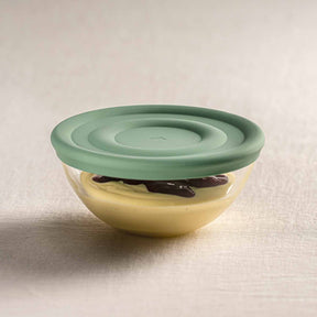 Silikondeckel CUCINA auf gelblicher Schale mit Vanilleschote, mintgrüner Deckel