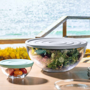 Silikondeckel CUCINA auf Schüsseln mit Salat und Tomaten, Seeblick im Hintergrund