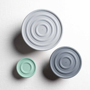 Drei Silikondeckel in verschiedenen Größen, grau und mintgrün, Draufsicht