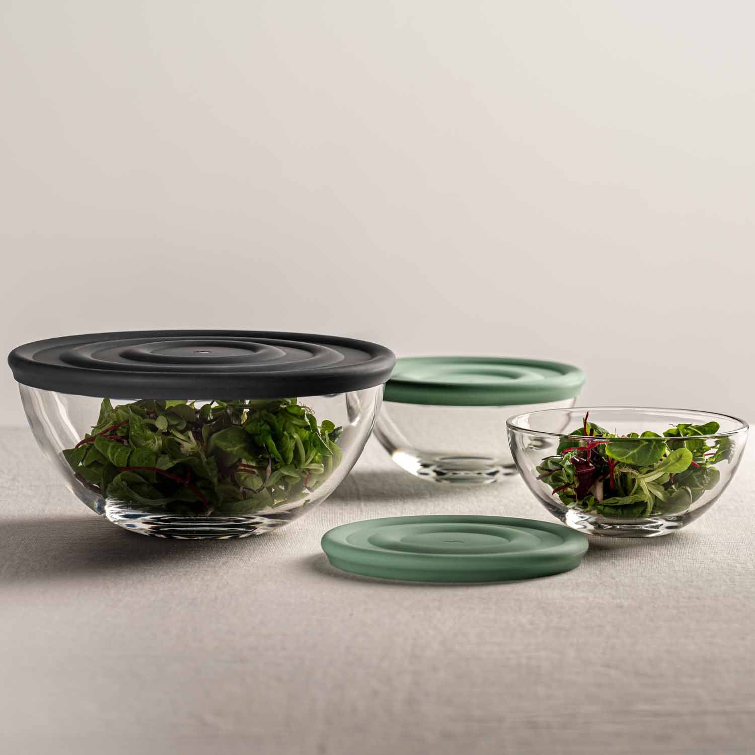 Schalenset CUCINA mit Glasschüsseln in verschiedenen Größen, mintgrüne und schwarze Deckel, gefüllt mit Salat