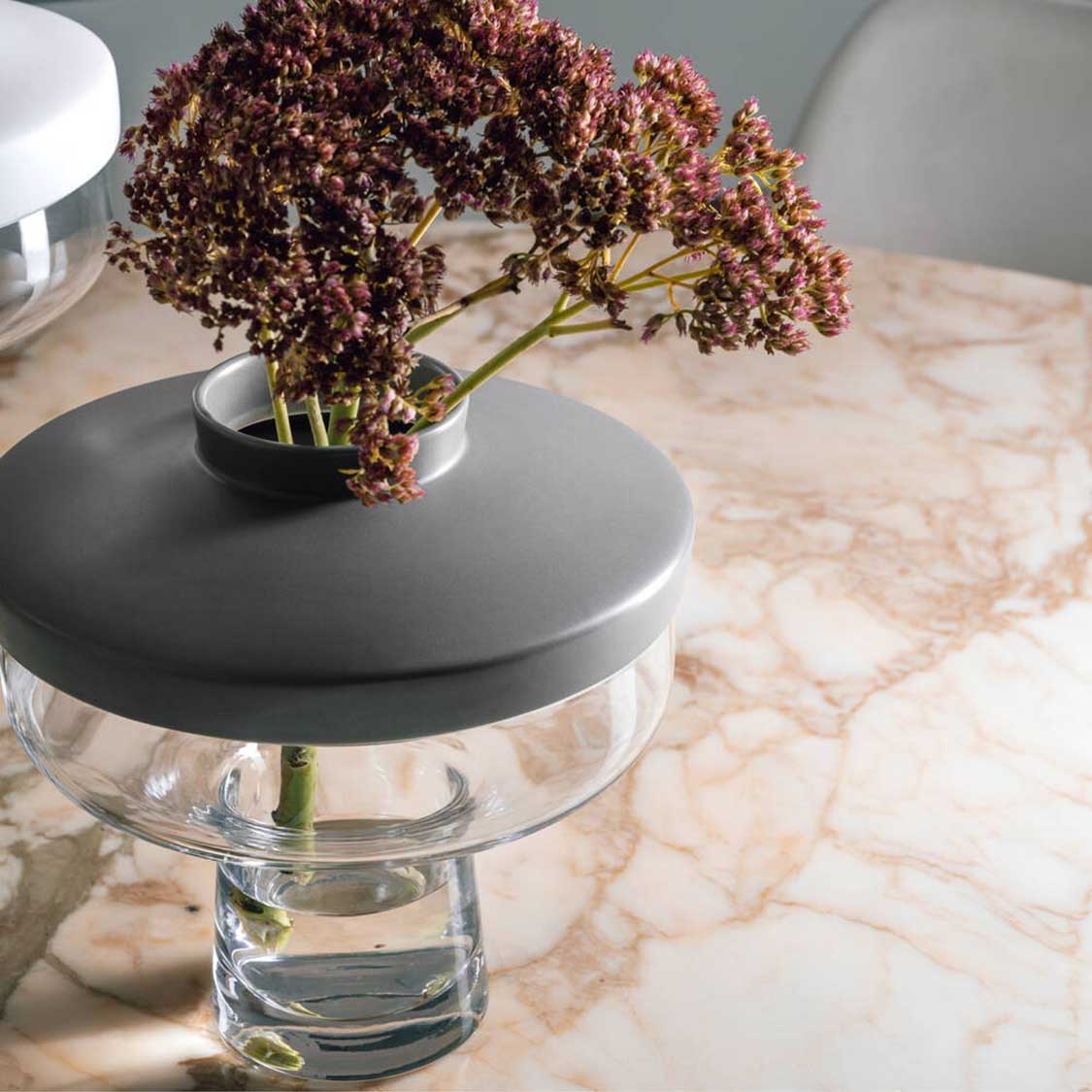 Vase RIVA mit grauem Aufsatz, gefüllt mit getrockneten roten Blüten auf Marmortisch