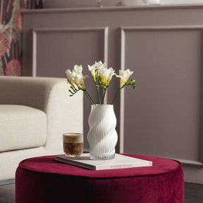 Vase VERDI 19 cm weiß mit weißen Blüten auf Wohnzimmertisch neben Buch und Glas