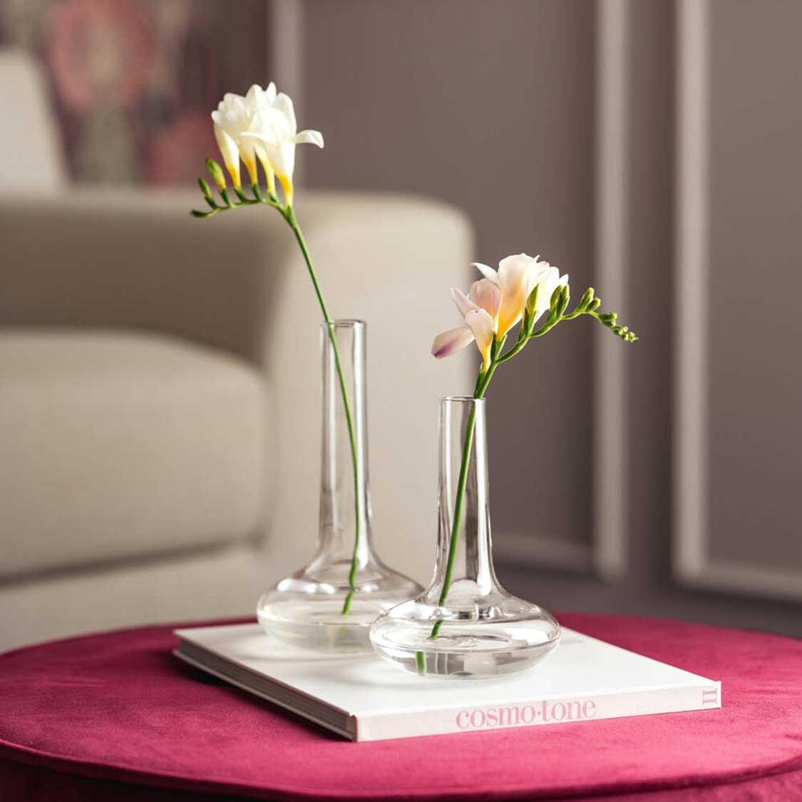 Solifleurfvasen ARIA mit weißen Blüten auf pinkem Tisch im Wohnzimmer