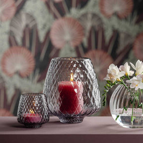 Windlicht GIULIA 20 cm grau mit brennender Kerze, daneben kleineres Windlicht und Blumenvase auf Tisch