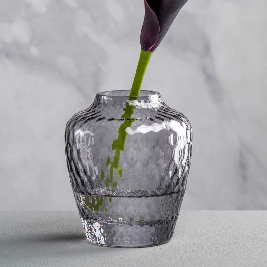 Vase GIULIA mit grünem Blumenstiel in Nahaufnahme gegen Marmor-Hintergrund