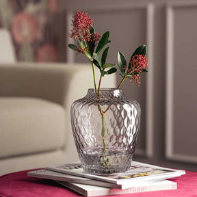 Vase GIULIA mit roten Blüten auf Tisch im Wohnzimmer