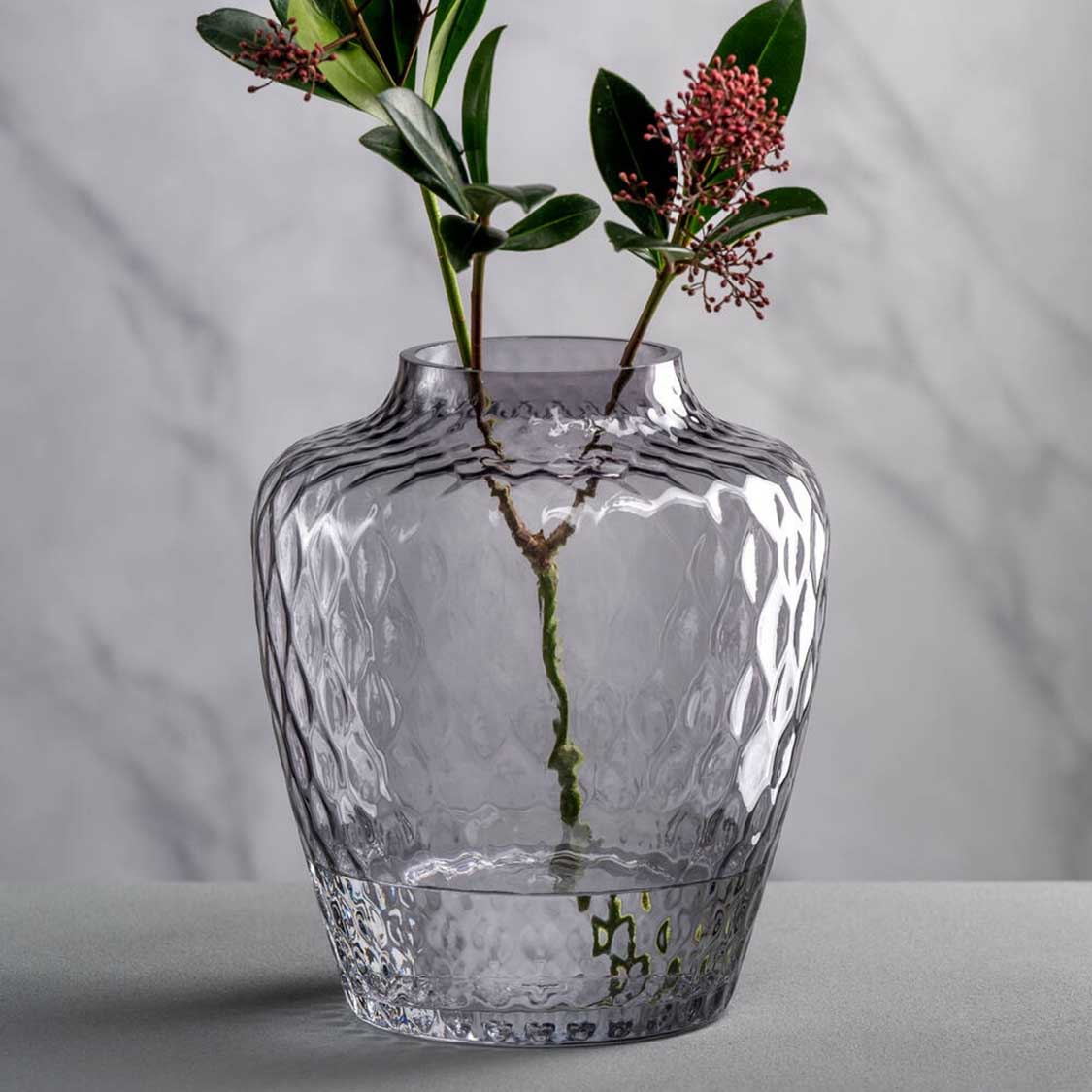 Vase GIULIA mit zwei Blumenzweigen in Wasser, strukturierte Glasoberfläche, auf weißem Untergrund