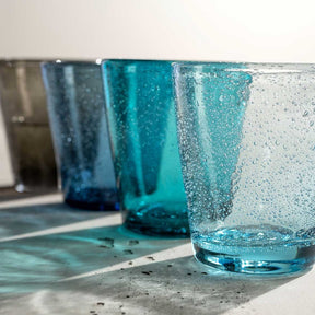 Vier Trinkgläser BURANO in Blau- und Türkistönen mit Wasser und Blasen gefüllt