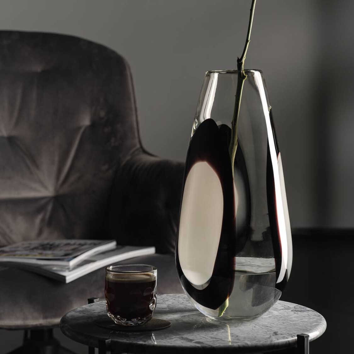 Vase OCCHI BIANCHI auf Marmortisch in Wohnraum mit Stuhl und Glas