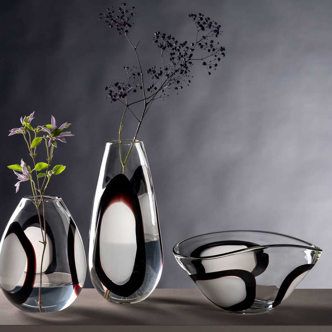 Schale OCCHI BIANCHI mit Vasen und Blumenzweigen auf grauem Hintergrund