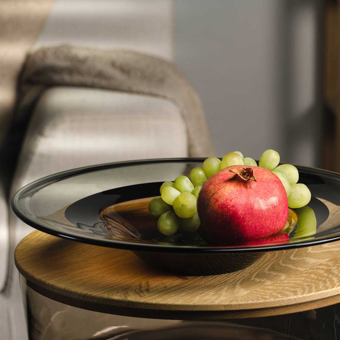 Schale CORSO SABBIA mit Granatapfel und grünen Trauben auf Holztisch
