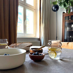 Trinkglas SOLE auf gedecktem Tisch mit Wasser, Obst und Brot