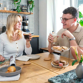 Korkuntersetzer GOCCE auf gedecktem Tisch in Wohnraum, Paar beim Kaffeetrinken