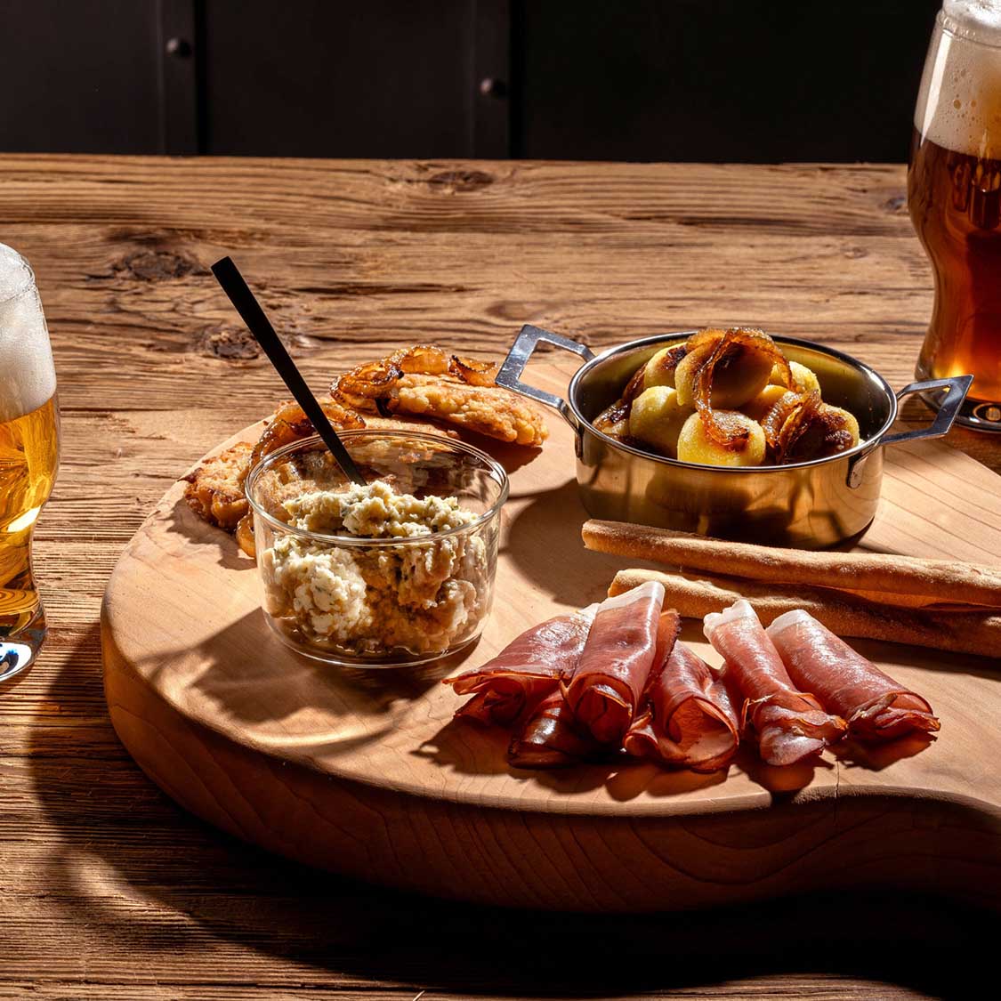 Schale VETRO mit Kartoffelsalat auf gedecktem Tisch mit Schinken und Getränken