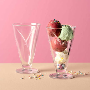 Eisbecher CONO mit Erdbeeren, Speiseeis und bunten Streuseln gefüllt, daneben leerer Becher