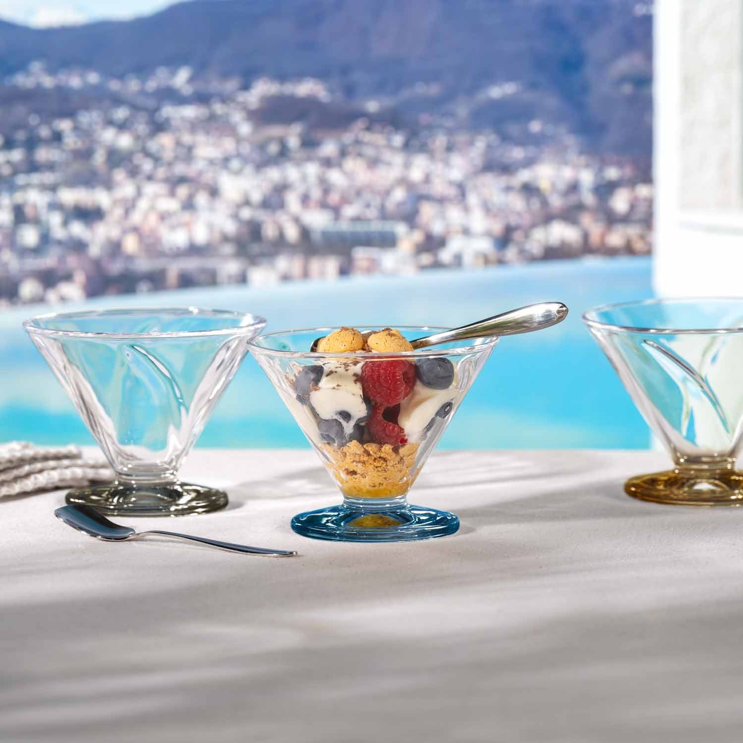 Eislöffel SOLE in drei Gläsern mit Früchten, Meerblick und Stadt im Hintergrund
