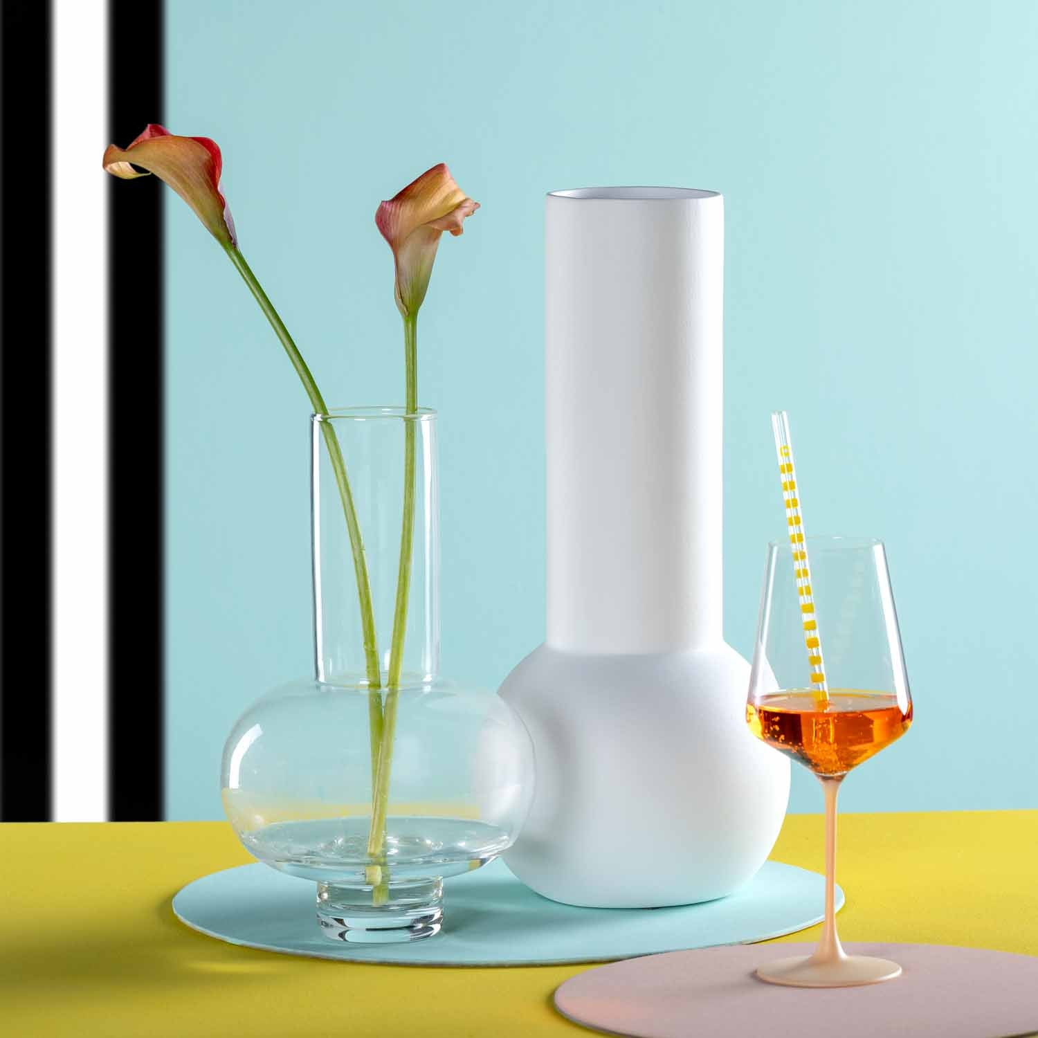 Keramikvase BRERA weiß mit Blumen in Glasvase und Weinglas auf farbigem Untergrund