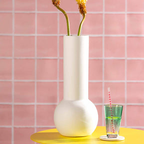 Keramikvase BRERA mit getrockneten Blüten auf gelbem Tisch vor rosa Fliesenwand