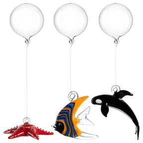 Drei Glashänger an Ballons: roter Seestern, blau-orange Fisch, schwarzer Orca