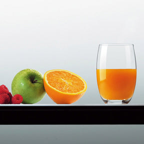 Trinkglas CHEERS mit Orangensaft, daneben Obst und Beeren