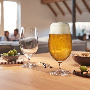 Bierglas CIAO+ mit Bier auf gedecktem Tisch, daneben Wasserglas und Snacks