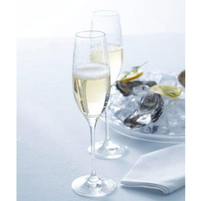 Sektglas CHATEAU mit Champagner gefüllt, daneben Austern auf Teller, weiße Serviette