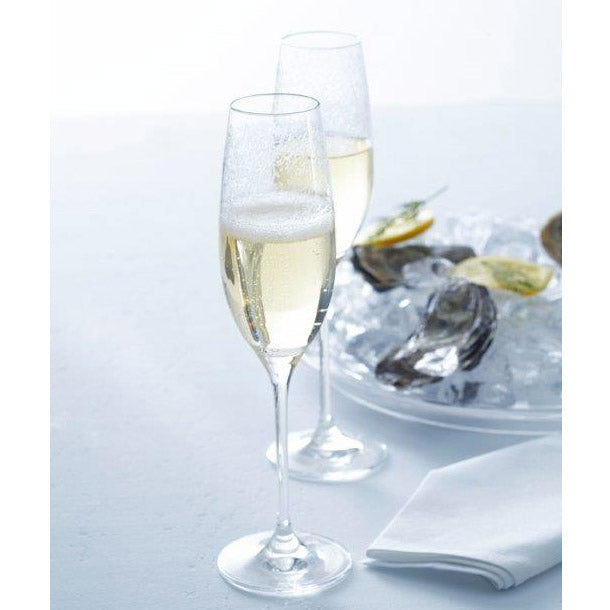 Sektglas CHATEAU mit Champagner gefüllt, daneben Austern auf Teller, weiße Serviette
