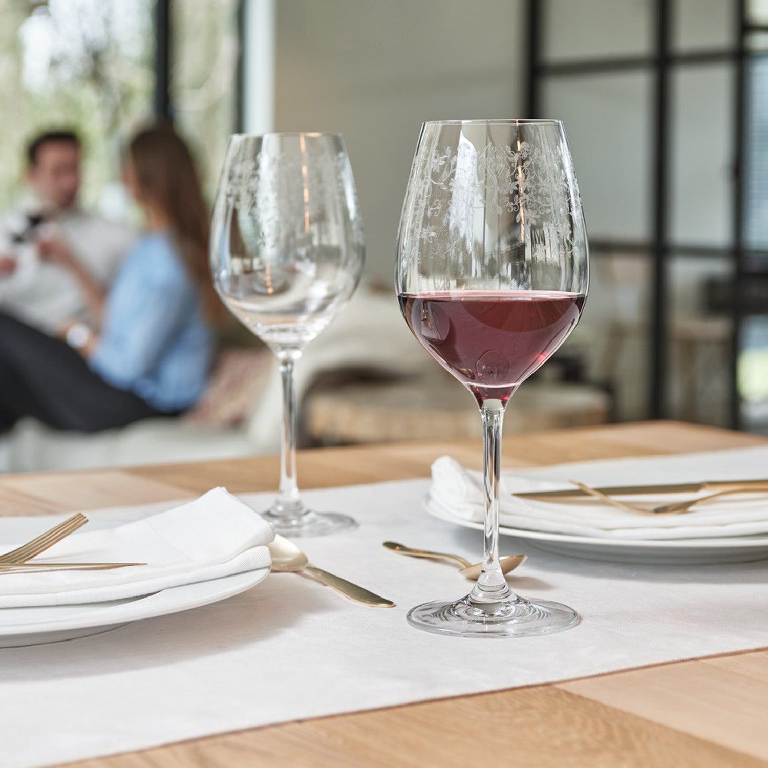Rotweinglas CHATEAU gefüllt mit Rotwein auf gedecktem Tisch bei Dinner