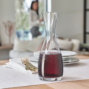 Karaffe CHATEAU mit Rotwein auf gedecktem Esstisch
