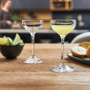 Likörschale CHEERS auf Holztisch in Küchenumgebung mit Getränken und Appetithäppchen