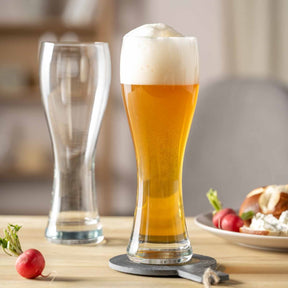 Weizenbiergläser MAXIMA mit Bier gefüllt, daneben leeres Glas, Radieschen und Brezel auf Tisch