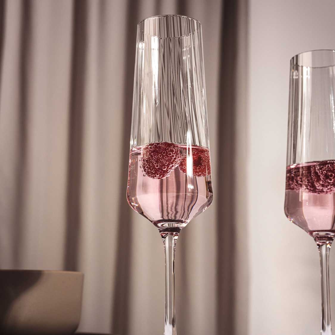 Sektglas PAOLO mit Roséwein und Eiswürfeln gefüllt, neben zweitem Glas vor Vorhang