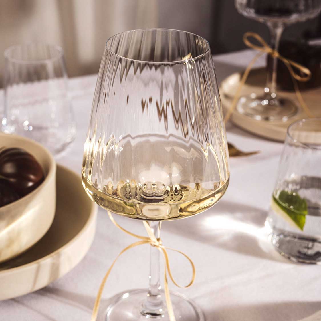 Weißweinglas PAOLO mit Weißwein auf gedecktem Tisch