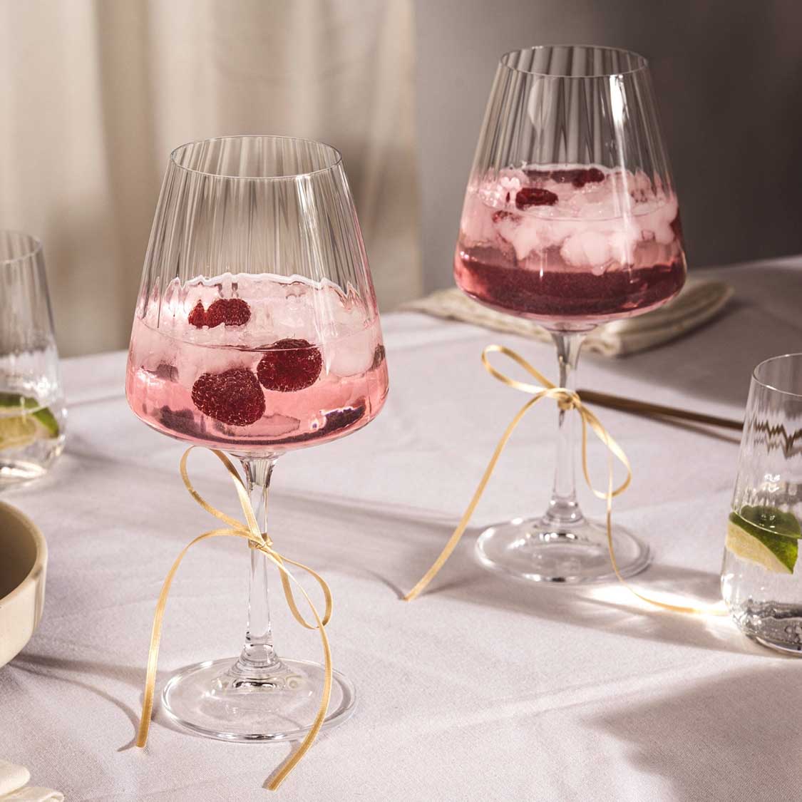 Weißweingläser PAOLO mit rosafarbenem Getränk und Beeren auf gedecktem Tisch