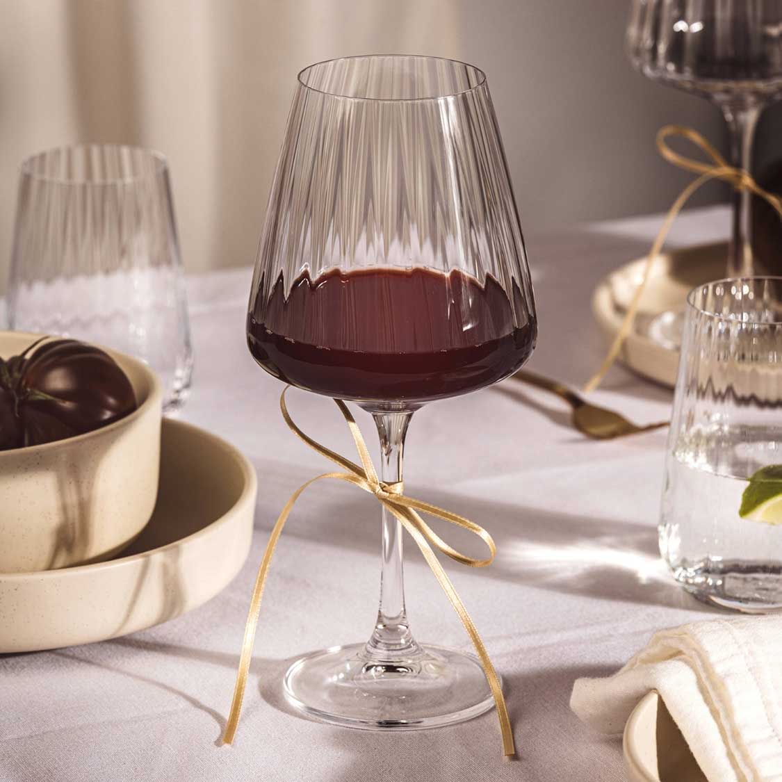 Rotweinglas PAOLO mit Rotwein gefüllt auf gedecktem Tisch