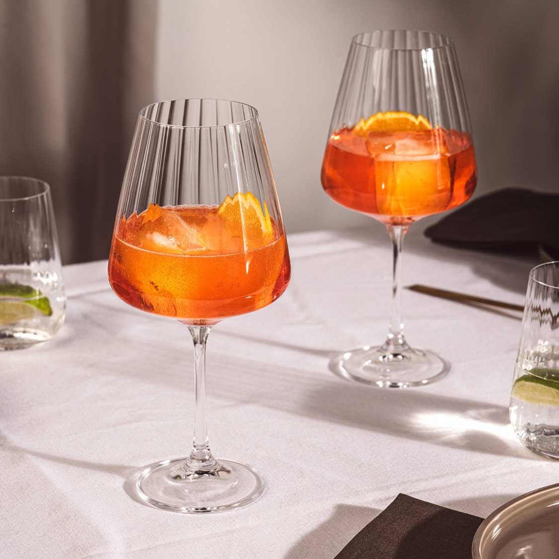 Rotweinglas PAOLO mit orangerotem Cocktail auf gedecktem Tisch