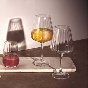 Elegante Glaeser auf Marmortisch, eines mit gelbem Getraenk und Zitronenscheibe gefuellt